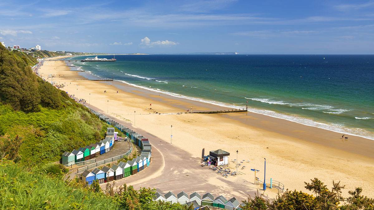 Bournemouth beach, pier, sea and sand. Sunshine illuminates golden beaches and blue-green seas along the Dorset coast at Middle Chine between Poole and Bournemouth